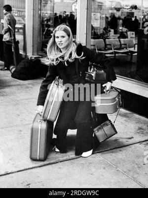 New York, New York: Oktober 1971 Eine junge Frau am LaGuardia Airport kämpft um ihre fünf Gepäckstücke. Stockfoto