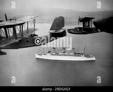 England: 22. Juni 1939 Royal Air Force Flugboote eskortieren die „Empress of Britain“, während sie heute den Solent hochsaugt. Stockfoto