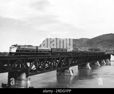 Kanada: c. 1949 Ein kanadischer Passagierzug, der einen Baustein über einen Fluss überquert. Stockfoto