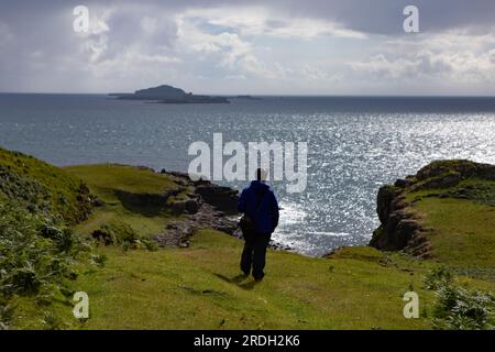 Eine Geherin in Blau, die auf die Treshnish Isles blickt, von der Insel Mull, Schottland Stockfoto