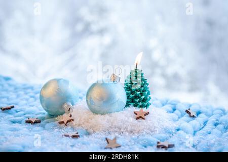 Hintergrundinformationen zu Weihnachtsprodukten. Blaue frostige Kugeln auf Schnee, Bokeh verschneiter Winterwald-Hintergrund. Stockfoto