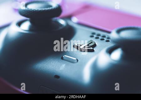 Brecht, Belgien - 14. juli 2023: Nahaufnahme des PS5-Logos und der Joysticks und Touchpads eines offiziellen kosmischen roten playstation 5-Videospiels Stockfoto