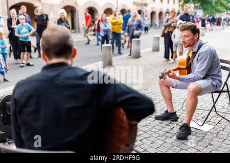 Nürnberg, Deutschland. 21. Juli 2023. Ein Gitarrenduo spielt im 46. Bardentreffen im Zentrum von Nürnberg. Es ist eines der größten Musikfestivals Deutschlands: Das Bardentreffen 46. begann am Freitag in Nürnberg. An neun Veranstaltungsorten in der Altstadt treten Musiker bei etwa 90 Konzerten auf. Gleichzeitig füllen Straßenkünstler und Musiker die Plätze und Gassen von Nürnberg. Kredit: Daniel Karmann/dpa/Alamy Live News Stockfoto