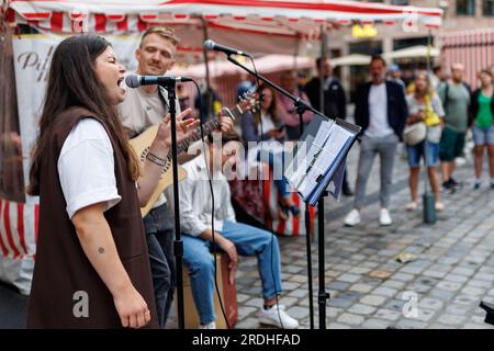 Nürnberg, Deutschland. 21. Juli 2023. Eine Band spielt im 46. Bardentreffen in der Fußgängerzone in Nürnberg. Es ist eines der größten Musikfestivals Deutschlands: Das Bardentreffen 46. begann am Freitag in Nürnberg. An neun Veranstaltungsorten in der Altstadt treten Musiker bei etwa 90 Konzerten auf. Gleichzeitig füllen Straßenkünstler und Musiker die Plätze und Gassen von Nürnberg. Kredit: Daniel Karmann/dpa/Alamy Live News Stockfoto