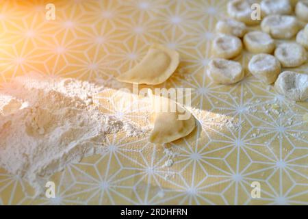 Teigtaschen und Teig zum Kochen in Mehl auf dem Tisch Stockfoto