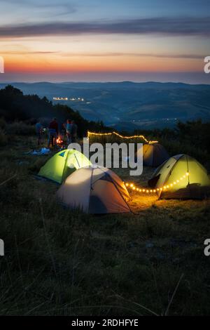 Am Abend beim Camping in den Bergen. Beleuchtete Zelte in einem malerischen Tal. Stockfoto