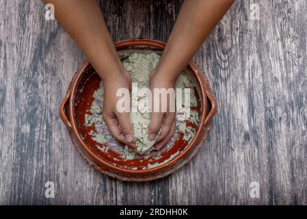 Die Hände der Frau mischen den Maisteig zu Tortillas. Mexikanisches, einfaches Essen. Stockfoto