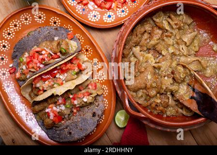 Chicharrones in grüner Sauce Tacos serviert mit Pico de gallo Salat. Typisch mexikanisches Essen. Stockfoto