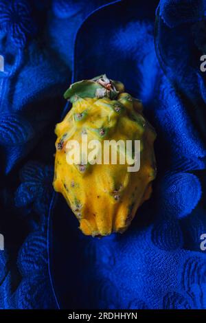 Gelbe Drachenfrucht, Drachenfrucht, Pitaya auf kobaltblauem Stoff Stockfoto