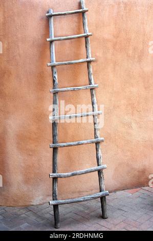 Die alte Leiter lehnt sich an die Wand eines lehmhauses in der „Altstadt“ in Albuquerque, New Mexico. Stockfoto