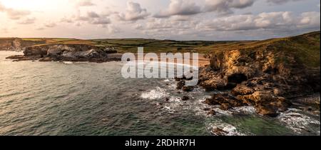 Panoramablick aus der Vogelperspektive auf Church Cove mit seiner historischen Kirche und den felsigen Klippen mit Schmugglerhöhlen bei Gunwalloe in Cornwall at s. Stockfoto