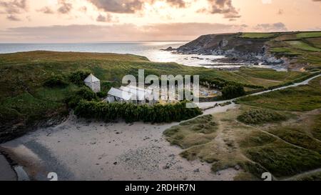 WINWALOE CHURCH, GUNWALLOE, CORNWALL, GROSSBRITANNIEN - 29. JUNI 2023. Blick aus der Vogelperspektive auf die mittelalterliche Kirche Winwaloe und den Friedhof in Church Cove bei Gunwal Stockfoto