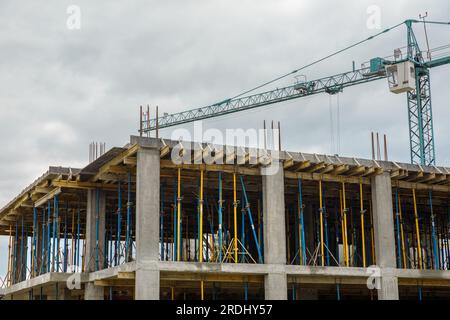 Bauprojekt, unfertige Bauarbeiten, Bauarbeiten, Baustelle, Wandbau, Bewehrungsstahl aus Metall, Gebäude und Kran, Stahlverstärkung Stockfoto