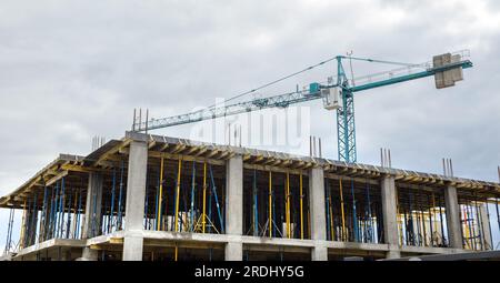 Gebäude im Bau, Bewehrungsstahl aus Metall, Bauprojekt, Gebäude und Kran, Fundamentarbeiten, Baustelle Stockfoto