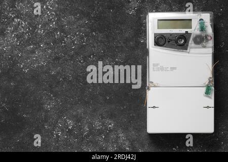 Stromzähler an grauer Wand, Platz für Text Stockfoto