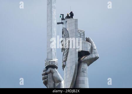 Kiew, Ukraine. 21. Juli 2023. Arbeiter werden dabei beobachtet, wie sie sich darauf vorbereiten, das sowjetische Wappen vom Schild der Mutterland-Skulptur in Kiew zu demontieren. Bis Ende August 2023 planen die ukrainischen Behörden, den ukrainischen Dreizack anstelle des sowjetischen Wappens auf dem Schild der berühmten Statue zu installieren. Die Ukraine führt seit 2014 eine aktive Dekommunisierung durch und verweigert die Namen, Symbole und Ideologie der Sowjetära in allen Lebensbereichen. Kredit: SOPA Images Limited/Alamy Live News Stockfoto