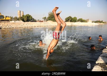 Gizeh, Ägypten. 21. Juli 2023. Ein Junge taucht in einen Kanal ein, um sich während einer Hitzewelle in Gizeh, Ägypten, am 21. Juli 2023 abzukühlen. Kredit: Ahmed Gomaa/Xinhua/Alamy Live News Stockfoto