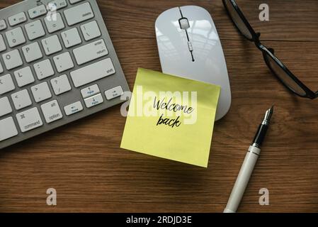 „Zurück zum Geschäft“, „Rückkehr zur Arbeit“ und „Wiederbeschäftigung“-Konzept. Begrüßungsnotiz auf einer Computermaus von einem Kollegen oder Boss Stockfoto