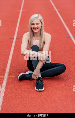 Eine wunderschöne junge College-Sportlerin bereitet sich auf ein Leichtathletiktreffen an einer örtlichen Universität vor Stockfoto