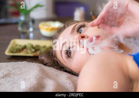 Ein wunderschönes braunes Model raucht Marihuana in der Privatsphäre ihres eigenen Zuhauses Stockfoto