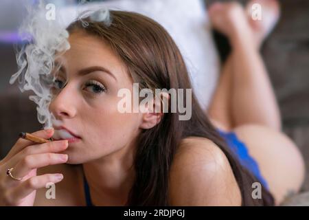Ein wunderschönes braunes Model raucht Marihuana in der Privatsphäre ihres eigenen Zuhauses Stockfoto