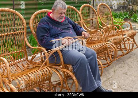 Ein ukrainischer Oberbefehlshaber sortierte Witzfiguren, während er im Sommergarten einen Schaukelstuhl baute Stockfoto