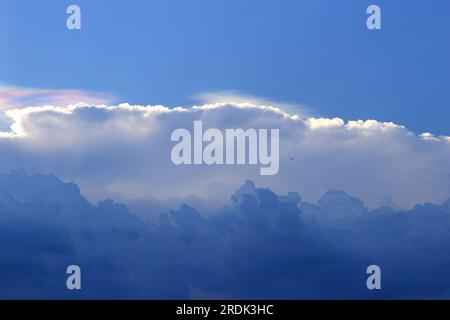 Wolken, die in wechselnden Schichten schwimmen, ähnlich wie Wasserfärbung. Stockfoto