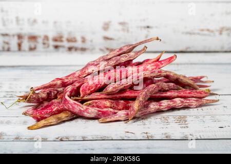 Kidnierenbohnen auf weißem Holzhintergrund. Konzept für die Ernte frischer roher Cranberry-Bohnen. Gemüse für eine gesunde Ernährung Stockfoto