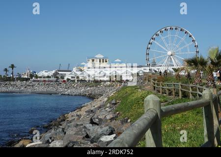 Lebhaftes Hafenviertel in Kapstadt hinter einer romantischen blauen Bucht mit Steinstrand. Stockfoto