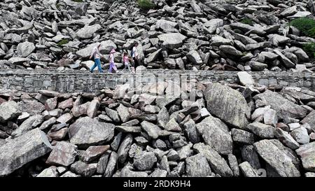 XI'an. 21. Juli 2023. Dieses Luftfoto wurde am 21. Juli 2023 aufgenommen und zeigt Besucher, die das Felsenmeer im Zhuque National Forest Park in Xi'an, Nordwestchina, in der Provinz Shaanxi passieren. Der Park, der sich im oberen Bereich des Flusses Ost-Laohe und im Norden des Qinling-Gebirges befindet, erstreckt sich über eine Fläche von 2.621 Hektar, und der höchste Punkt des Bingjing-Gipfels hat eine Höhe von 3.015 Metern. Atemberaubende Landschaften wie unberührte Wälder, Gletscherreste und Wolkensee können Sie entlang der Straße zum Gipfel sehen. Kredit: Liu Xiao/Xinhua/Alamy Live News Stockfoto