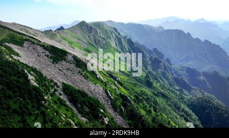 XI'an. 21. Juli 2023. Dieses Luftfoto wurde am 21. Juli 2023 aufgenommen und zeigt die Landschaft im Zhuque National Forest Park in Xi'an, Nordwestchina der Provinz Shaanxi. Der Park, der sich im oberen Bereich des Flusses Ost-Laohe und im Norden des Qinling-Gebirges befindet, erstreckt sich über eine Fläche von 2.621 Hektar, und der höchste Punkt des Bingjing-Gipfels hat eine Höhe von 3.015 Metern. Atemberaubende Landschaften wie unberührte Wälder, Gletscherreste und Wolkensee können Sie entlang der Straße zum Gipfel sehen. Kredit: Liu Xiao/Xinhua/Alamy Live News Stockfoto