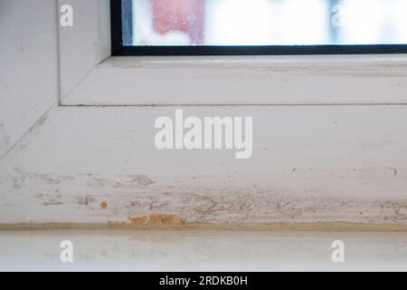 Teil des verschmutzten Fensterrahmens nach der Montage von Kunststofffenstern und dem Entfernen von Klebeband. Stockfoto