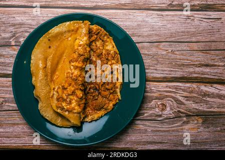 Gringa, typisch mexikanisches Gericht. Gringa Pastor a la diabla serviert mit Saucen und anderen Gewürzen auf einem Holztisch. Stockfoto