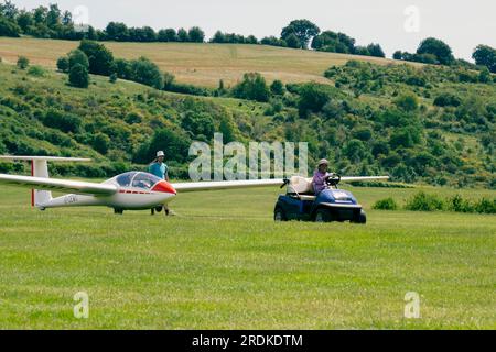 Eine Person zieht einen Gleiter mit einem Golfwagen auf einer Landebahn im Süden Englands in Großbritannien entlang des Bodens Stockfoto