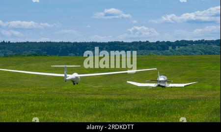 Ein Gleiter wird von einem Schleppflugzeug auf einer Landebahn im Süden Englands gezogen Stockfoto