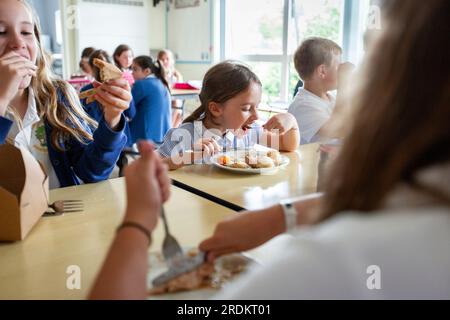 Mädchen essen in einer Grundschule in Worcestershire, Großbritannien. Stockfoto
