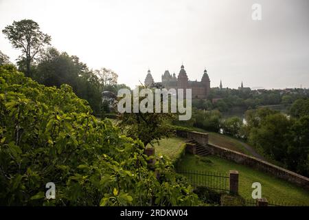 Majestätischer Sonnenaufgang: Schloss Johannisburg in Aschaffenburg, Main River. Ein atemberaubendes Spektakel, wenn die Morgensonne durch den ätherischen Nebel dringt Stockfoto