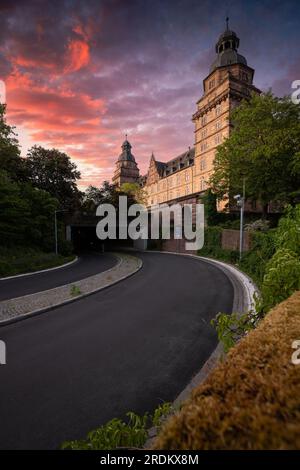 Majestätischer Sonnenaufgang: Schloss Johannisburg in Aschaffenburg, Main River. Ein atemberaubendes Spektakel, wenn die Morgensonne durch den ätherischen Nebel dringt Stockfoto