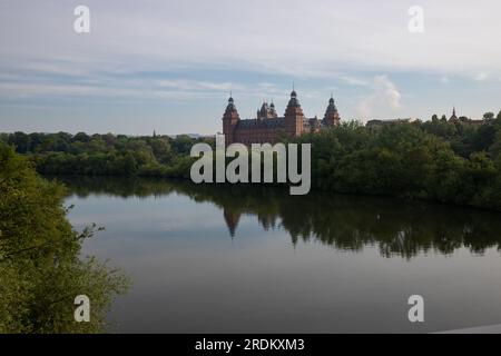 Majestätischer Sonnenaufgang: Schloss Johannisburg in Aschaffenburg, Main River. Ein atemberaubendes Spektakel, wenn die Morgensonne durch den ätherischen Nebel dringt Stockfoto