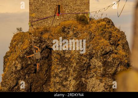 Rovensko Pod Troskami, Tschechische Republik. 21. Juli 2023. Slackliner durchquerten die 100 Meter lange Strecke zwischen den Türmen Baba und Panna der Ruinen des Troskjakschlosses in Rovensko pod Troskami, Region Semily, Tschechische Republik, mit einem Seil, das am 21. Juli 2023 in einer Höhe von 50 Metern befestigt wurde. Fans des Sports Slackline, modernes Seilwandern, demonstrierten hier im Rahmen der Wochenendveranstaltung Lanochodci na Troskach ihre Fähigkeiten. Die sogenannte Grand Virgin Line, die sich über Trosky erstreckt, ist eine der längsten und schönsten in der Tschechischen Republik. Kredit: Radek Petrasek/CTK Photo/Alamy Live News Stockfoto