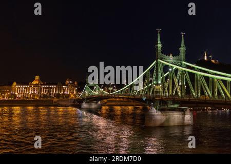 Die beleuchtete Freiheitsbrücke über der Donau zwischen Buda und Pest mit dem Gellert Hotel im Hintergrund, Budapest, Ungarn Stockfoto