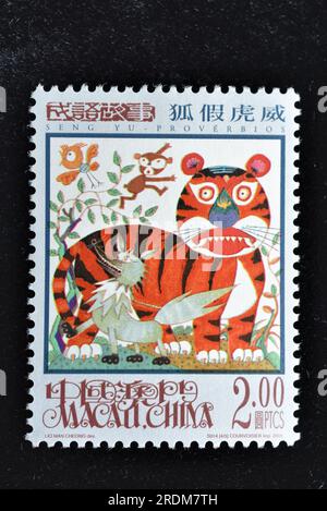 MACAU - CA. 2001: Eine in Macao gedruckte Briefmarke zeigt Seng Yu Idioms - Einen Fuchs, der sich die Grausamkeit des Tigers borgt, ca. 2001 Stockfoto