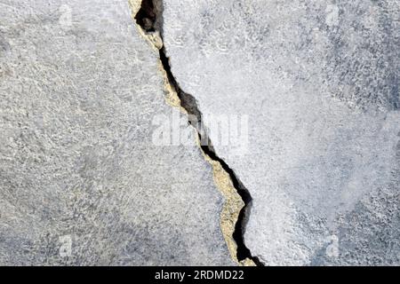 Großer Riss an der alten Putzwand. Langer Wicklungsriss in der Oberfläche eines alten Gebäudes. Speicherplatz kopieren. Selektiver Fokus. Stockfoto