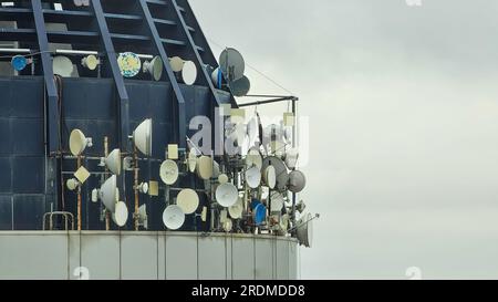 Auf dem Dach des Gebäudes installierte Telekommunikationsschüsseln, einschließlich Antennen für Radiotafeln und Funkgeräte für den Außenbereich Stockfoto