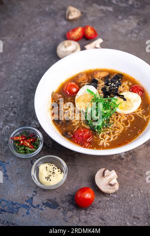 Würzige traditionelle Ramen mit Eiern, Pilzen und Meeresfrüchten von oben. Stockfoto