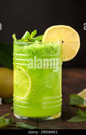 Limonade mit Eis und Minze in Glas auf Holztisch Stockfoto