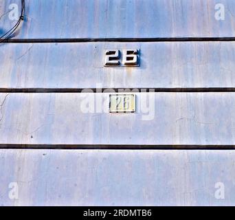 Nummer 26, 26, an der alten verwitterten blauen Wand. Stockfoto