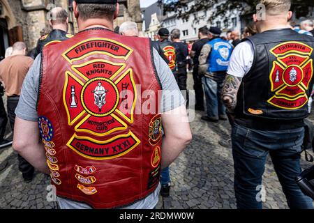 Ratingen, Deutschland. 22. Juli 2023. Mitglieder der Roten Ritter, ein Motorradclub der Feuerwehrleute, stehen während der Gedenkfeier nach der Motorradsternfahrt für die Opfer des Angriffs in Ratingen im Mai, bei der auch mehrere Notfallpersonal schwer verletzt wurden. Bei einer Explosion wurden 35 Menschen verletzt. Das Motto der Charity-Motorradfahrt lautet „Keine Gewalt gegen Rettungsdienste“. Kredit: Christoph Reichwein/dpa/Alamy Live News Stockfoto