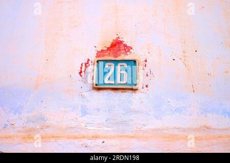 Nummernschild 26, 26, farbenfrohe blaue und rosa Wand. Stockfoto