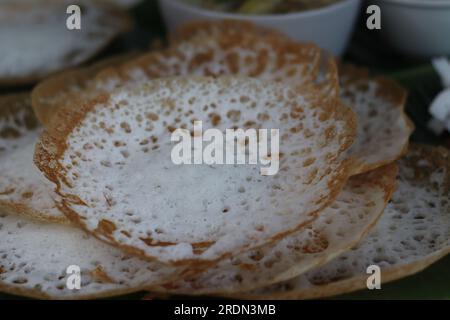 Reiskuchen mit Schnürsenkel serviert mit kerala-Hühnereintopf. Fermentierte Reispfannkuchen aus fermentiertem Reisteig und Kokosmilch. Lieblingsfrühstück Stockfoto